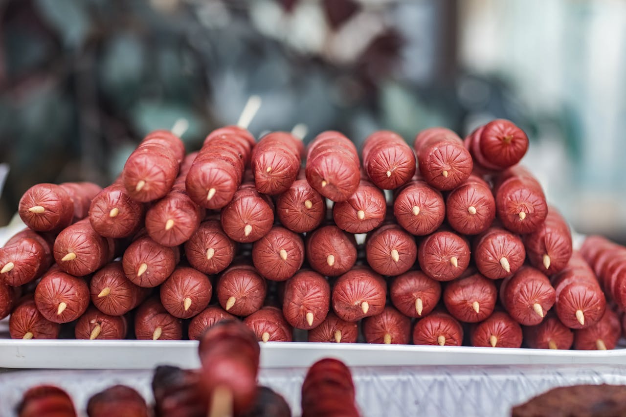 Close-up of stacked uncooked hotdogs on skewers ready for grilling, ideal for summer barbecues.